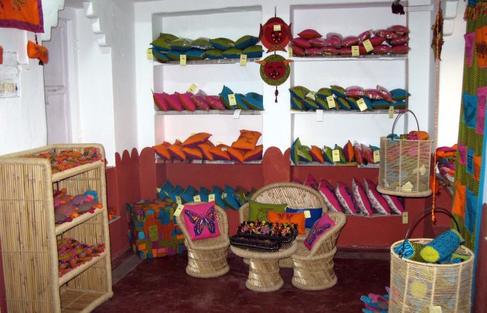 Interior view of Dastkar shop displaying colorful handcrafted textiles and cushions
